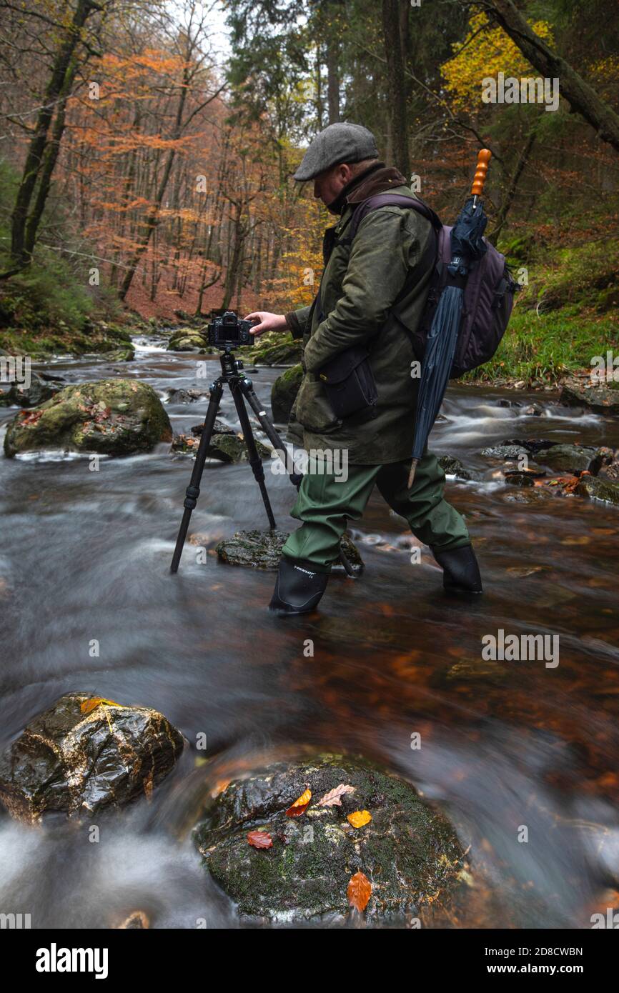 Photographe avec appareil photo et trépied dans la rivière Hogne dans les hautes fens, Belgique, Wallonie, Ardennes, Hockai Banque D'Images