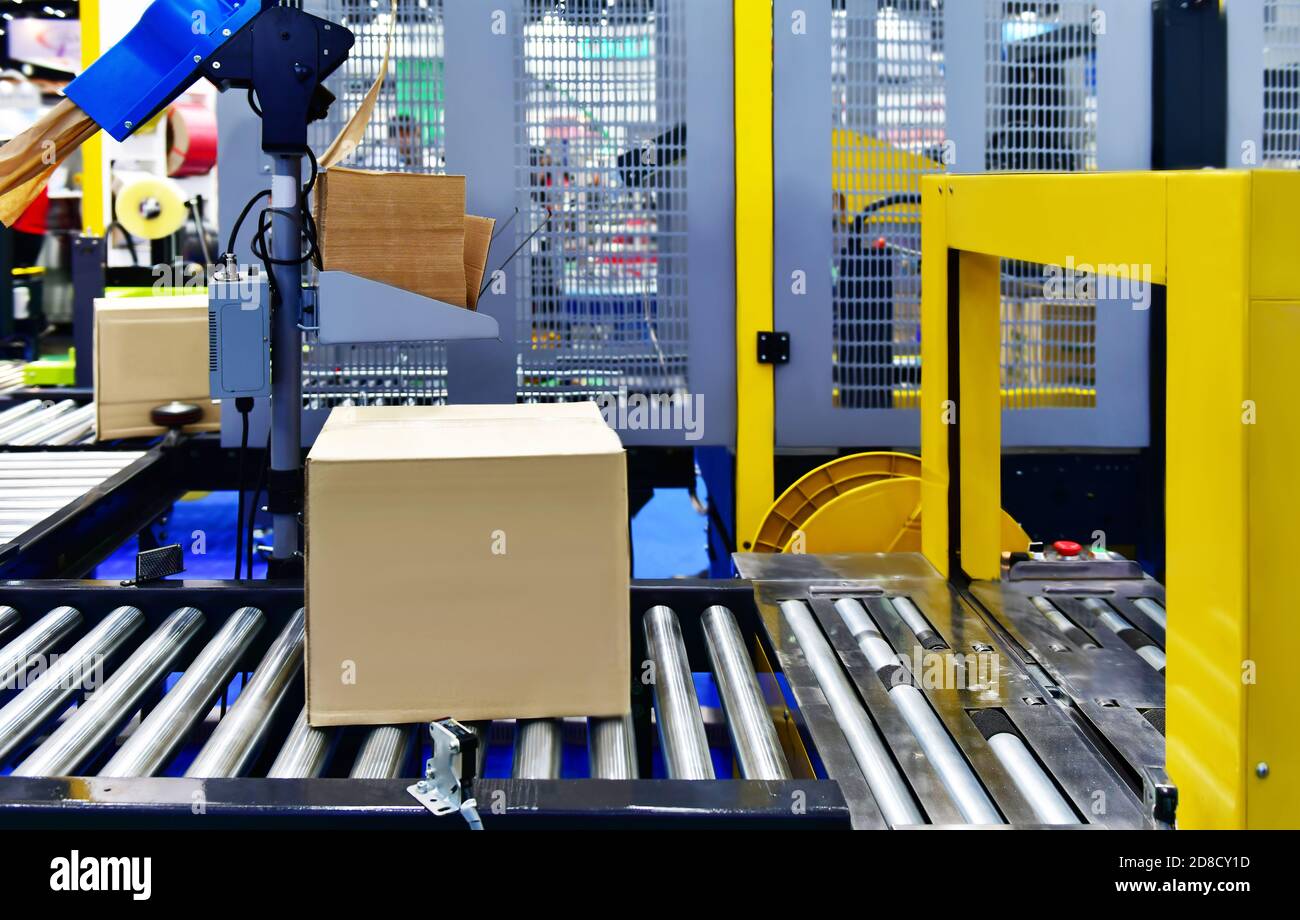 Boîtes en carton sur le tapis roulant concept de système de transport de colis Banque D'Images
