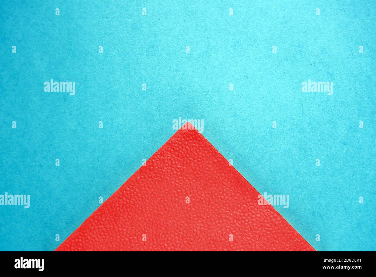 partie triangulaire de la serviette en papier rouge sur fond de carton bleu, espace de copie, vue de dessus Banque D'Images