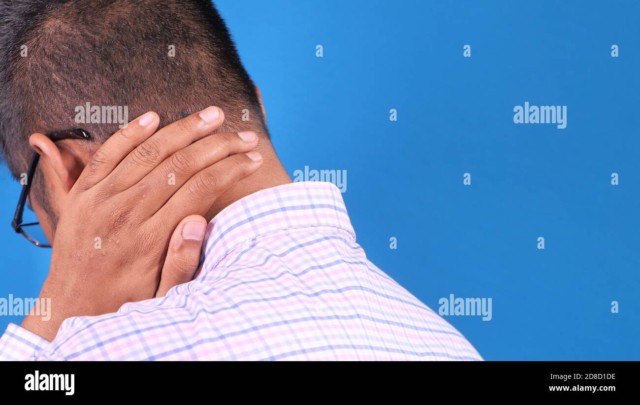 homme souffrant de douleurs au cou ou à l'épaule sur fond bleu Banque D'Images