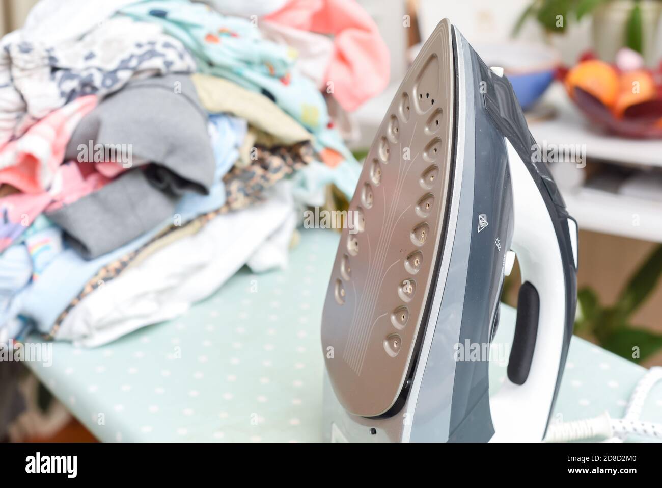 Le travail à la maison et les tâches à la maison fer vapeur avec un pile de vêtements à repasser Banque D'Images