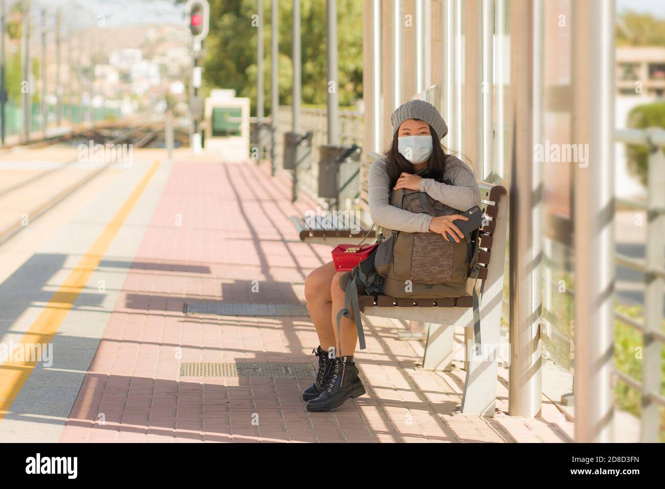 Jeune belle et heureuse femme touristique asiatique voyage pendant la nouvelle Normal - fille chinoise attrayante avec sac à dos en attente pour le train au plateau de la station Banque D'Images