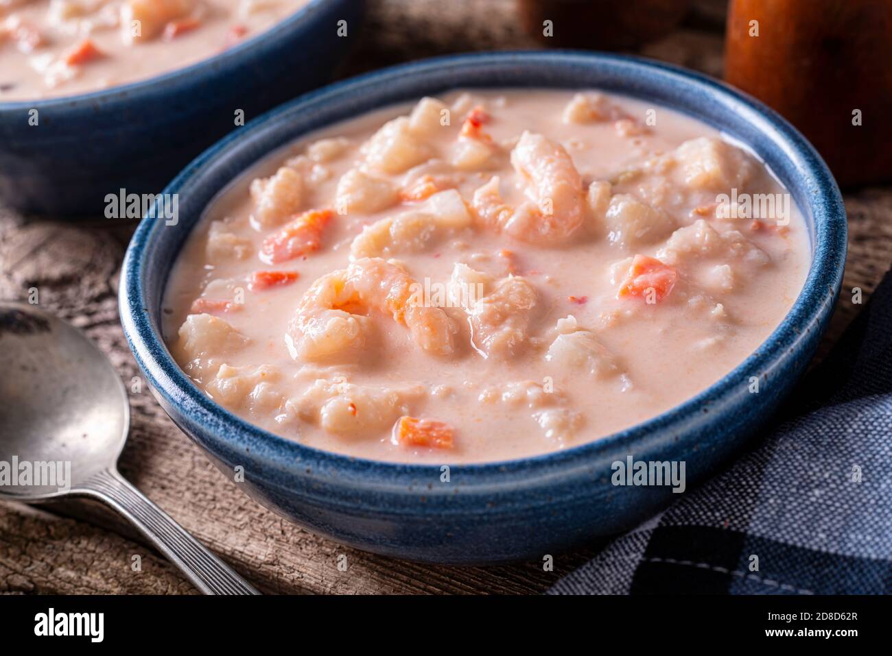 Un bol de délicieux chaudrée de fruits de mer avec homard, crevettes, pétoncles, pommes de terre, carottes et crème. Banque D'Images