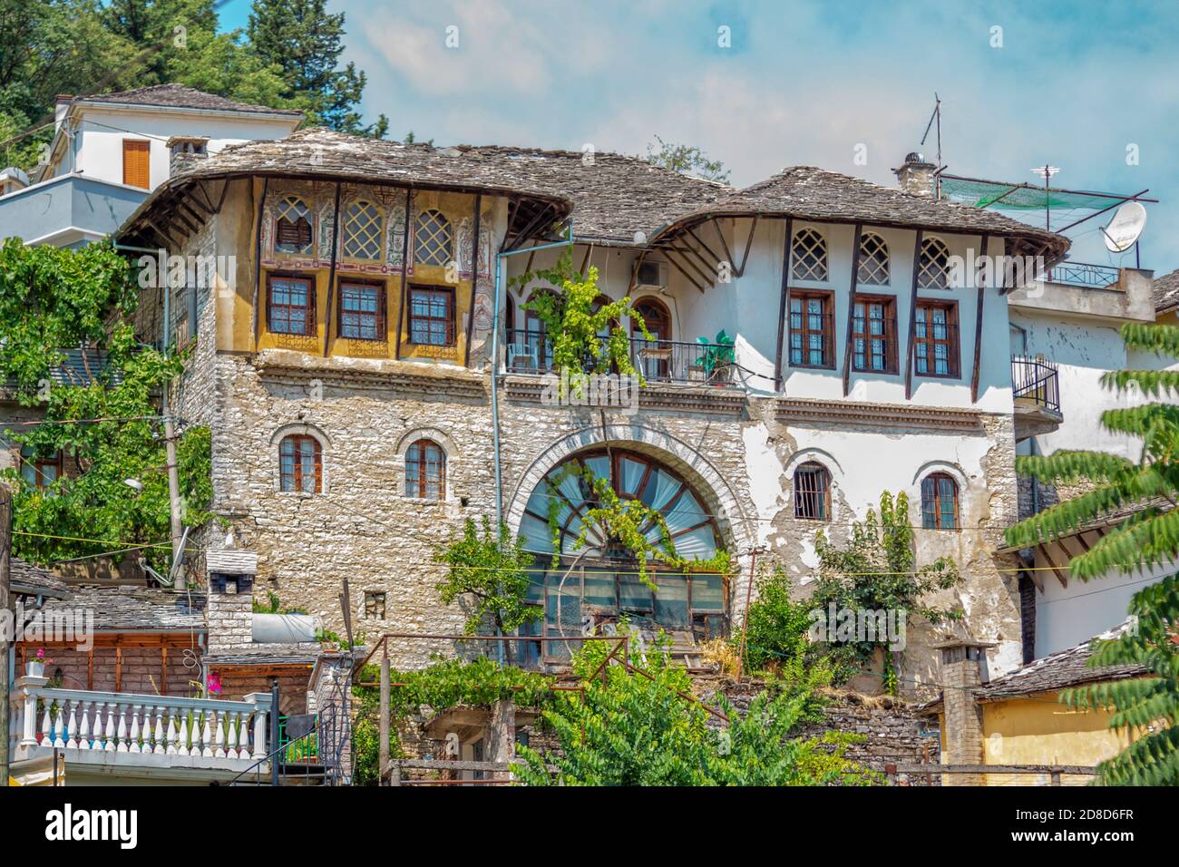 Gjirokaster ville/ Albanie – 2 août 2020 : architecture traditionnelle – ancienne maison avec toit en pierre grise et fenêtres voûtées. Paysage urbain d'été historique Banque D'Images