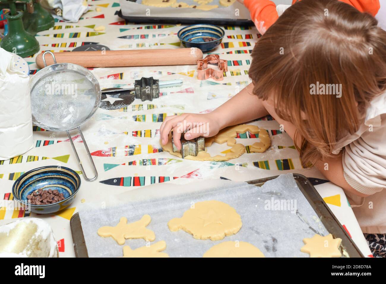 Les enfants cuisent des biscuits dans la cuisine avoir plaisir à ajouter des ingrédients pour cuisiner les aliments Banque D'Images