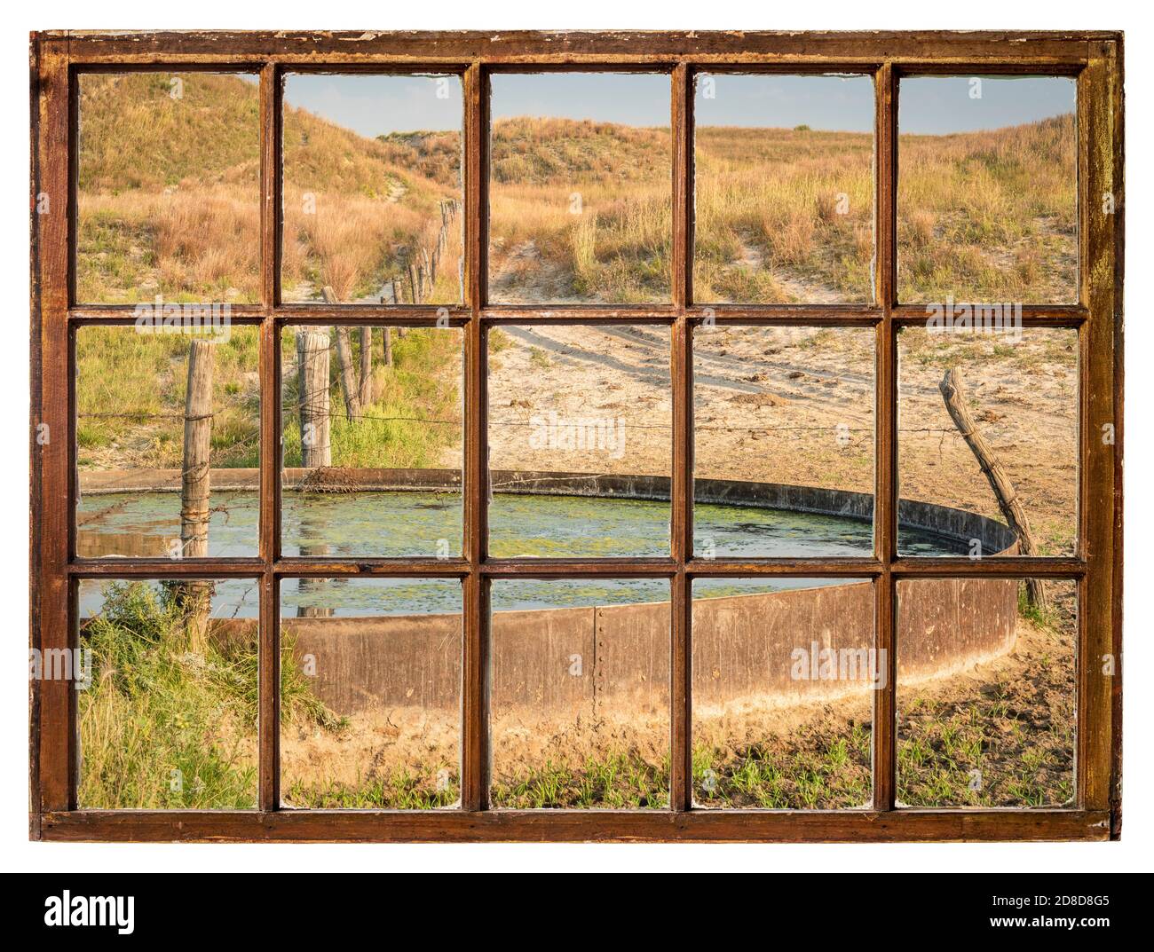 Trou de boisson de bétail dans une prairie de Nebraska Sandhills - paysage d'automne le matin vu d'une fenêtre à guillotine vintage Banque D'Images