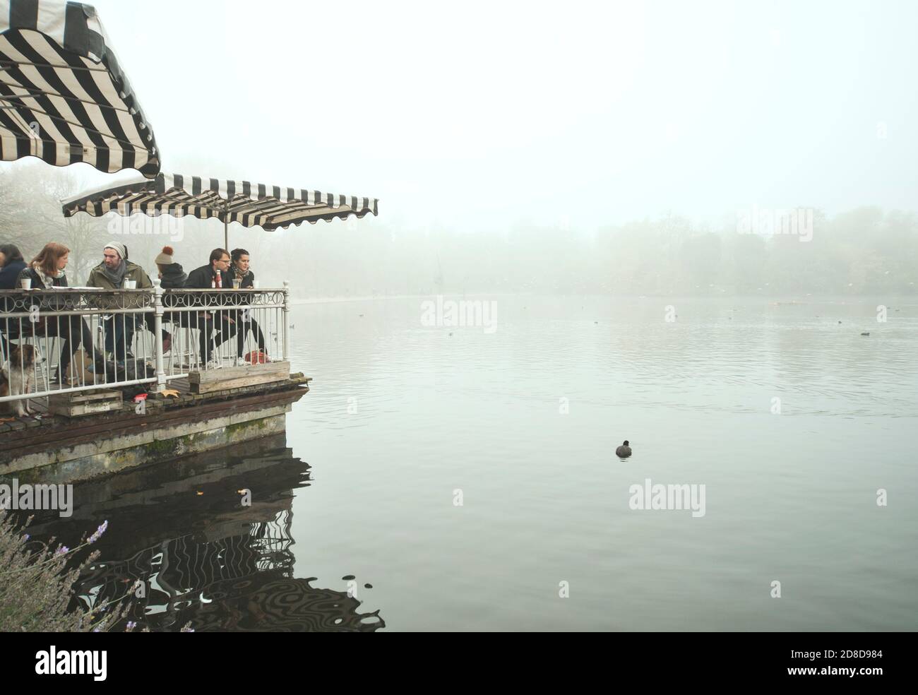 Vibes brumeux de Londres. Couple regardant le lac de noisette au Pavilion Cafe, Victoria Park, Londres, Royaume-Uni Banque D'Images