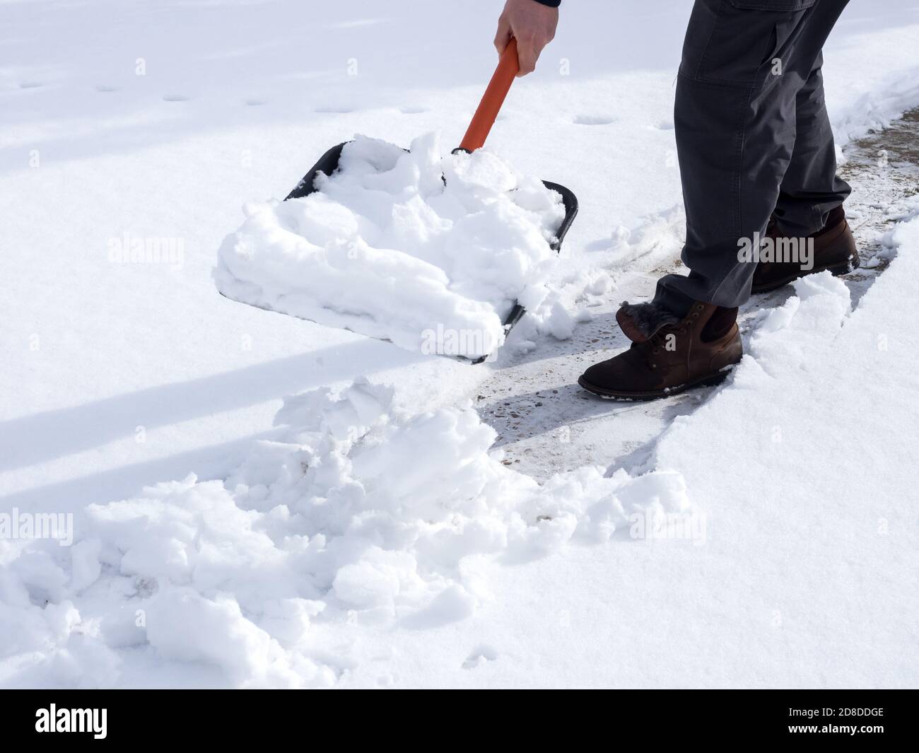 Gros plan sur une photo d'un travailleur qui a fait de la neige sur le trottoir Banque D'Images