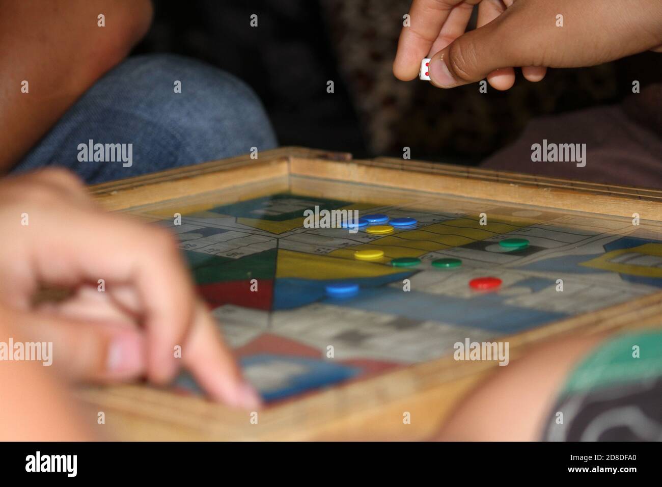 HOMME de la main de lancer deux dés jouant Parcheesi, jeu de Parchis sur le plateau de jeu Banque D'Images