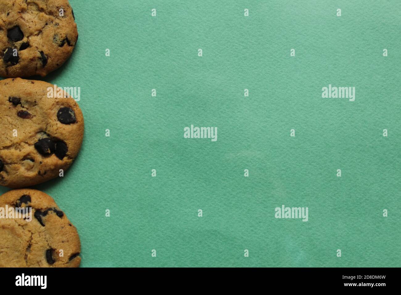 les biscuits de fond de nourriture sont ronds avec des gouttes de chocolat à côté vue de dessus de l'arrière-plan en herbe verte de l'espace de copie Banque D'Images