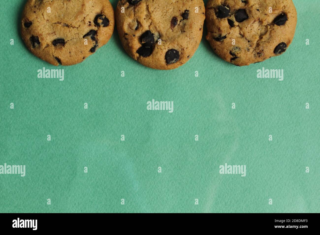 les biscuits de fond de nourriture sont ronds avec des gouttes de chocolat à côté vue de dessus de l'arrière-plan en herbe verte de l'espace de copie Banque D'Images