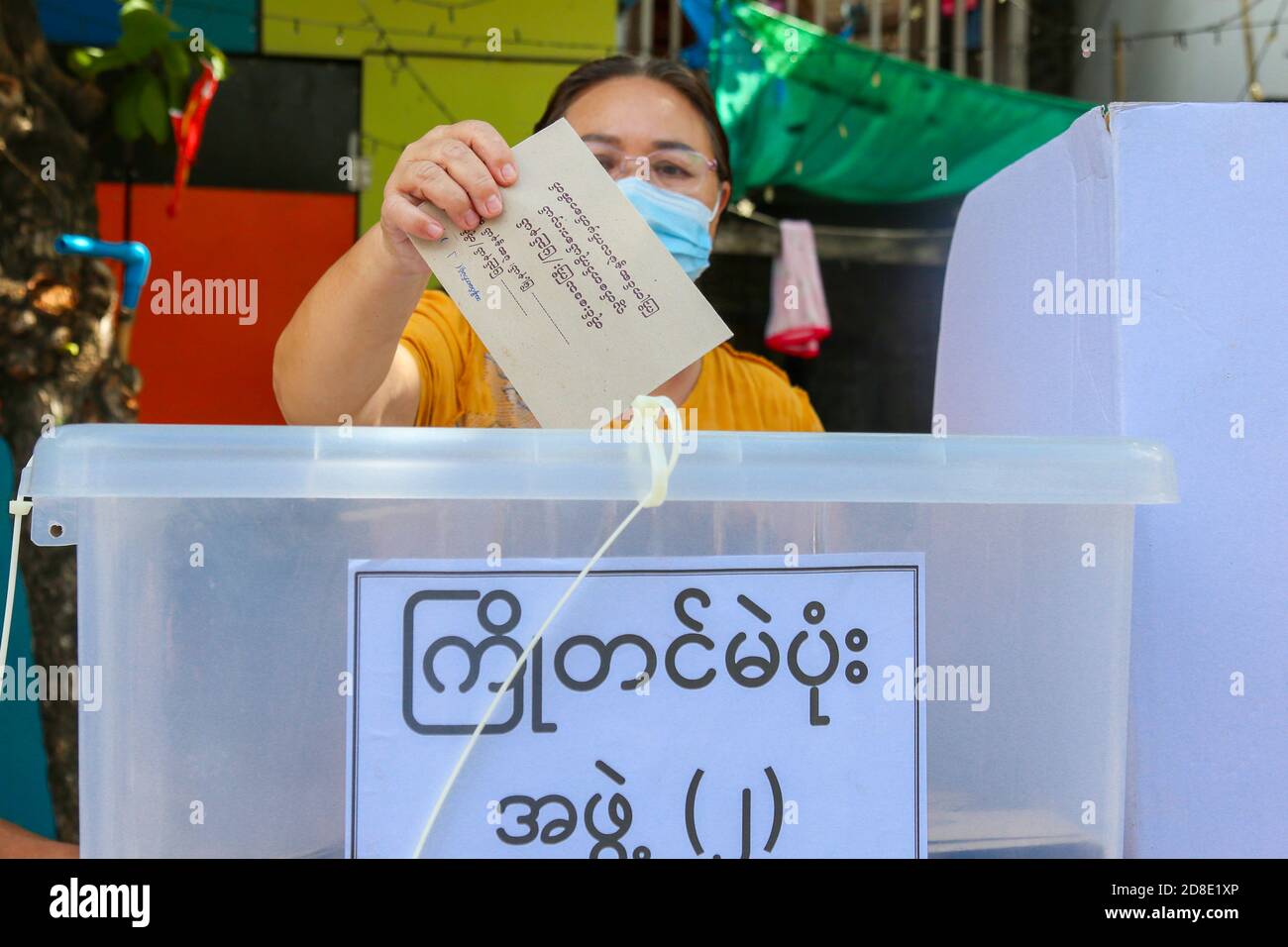 Une femme âgée portant un masque facial et un écran facial lance son bulletin de vote à un bureau de vote.la commission électorale de l'Union vote à l'avance pour les personnes âgées de plus de (60) ans. Les électeurs de plus de (60) ans du canton de Mandalay, Aung Myay Thar Zan, pourront voter à l'avance le matin du 29 octobre. Les élections générales du Myanmar auront lieu le 8 novembre. Banque D'Images