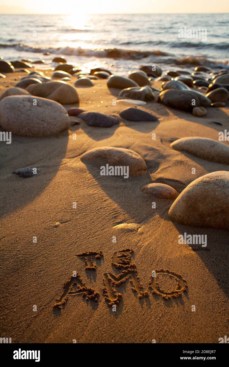 Plage de sable et de rocailleux au coucher du soleil avec 'te amo' (Je t'aime) écrit dans le sable Banque D'Images