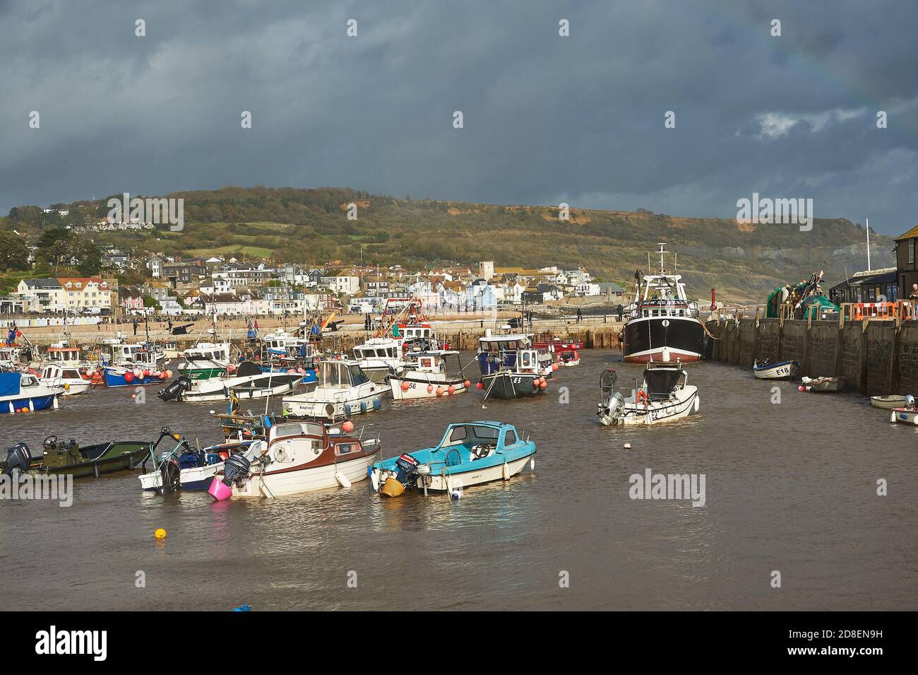 Lyme Regis, Dorset et les bateaux de pêche abri dans le port sous le ciel orageux automnal. Banque D'Images