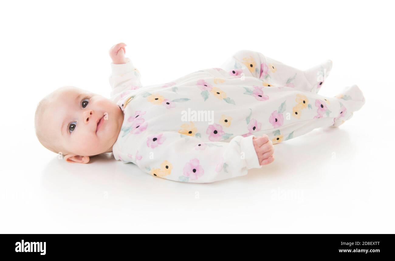 jeune fille de 3 mois couchée au sol isolée sur un fond blanc. Banque D'Images