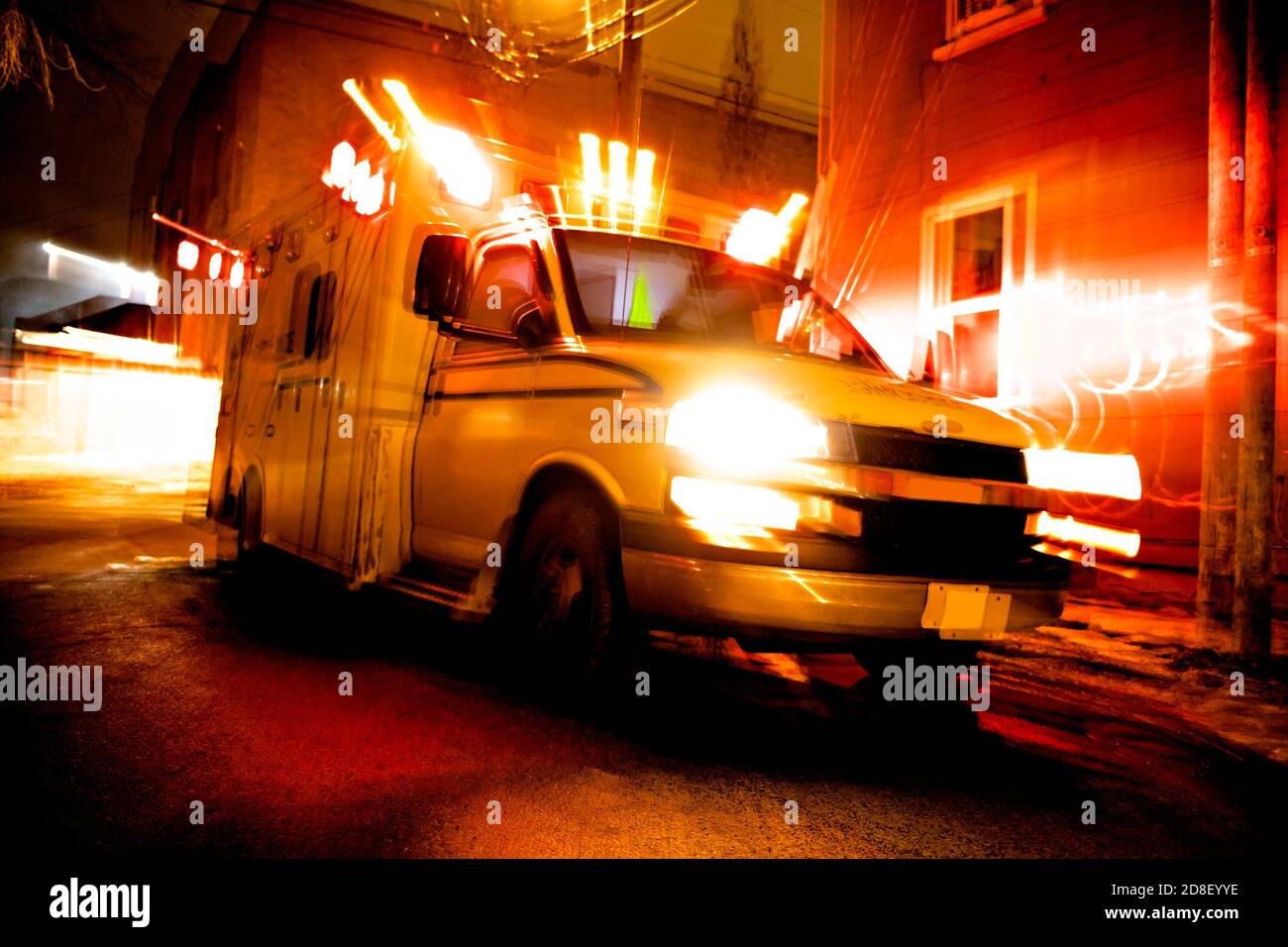 Une ambulance garée dans la rue latérale la nuit Banque D'Images