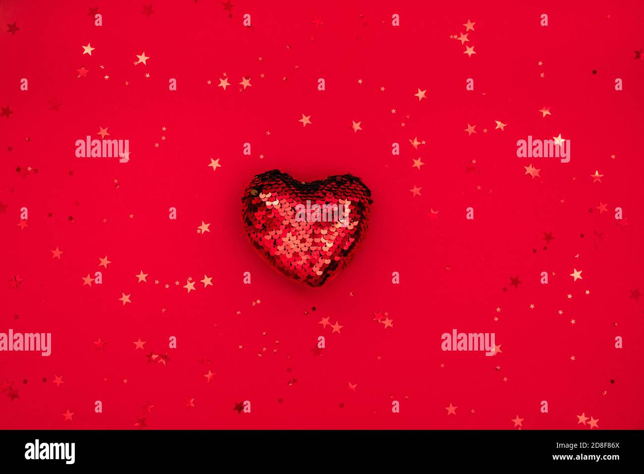 Composition de Noël ou de Saint-Valentin en coeur scintillant et paillettes sur surface rouge. Joyeux noël et bonne année 2021, heureux Banque D'Images