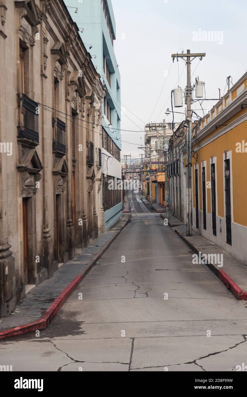 Petite rue vide de la ville coloniale tôt le matin par jour nuageux - rue du centre historique de Quetzaltenango Guatemala Banque D'Images