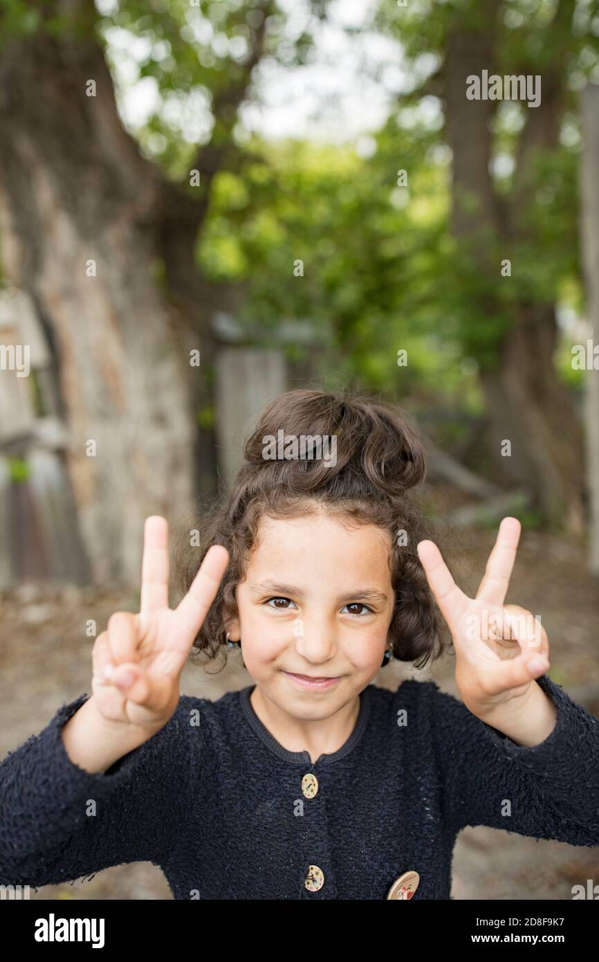 Une jeune fille de sept ans signe la paix à Gori, en Géorgie, dans le Caucase et en Europe de l'est. Banque D'Images