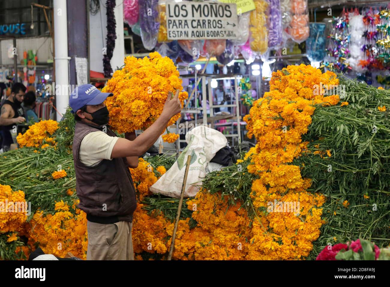 Mexico, Mexique. 29 octobre 2020. MEXICO, MEXIQUE - OCTOBRE 29 : une personne porte un masque facial lorsqu'elle vend des fleurs de Cempasuchil sur le marché extérieur, à l'occasion des célébrations de la Journée mexicaine des morts dans le cadre de la nouvelle pandémie de Covid-19, le 29 octobre 2020 à Mexico, au Mexique. Crédit: Leonardo Casas/ Eyepix Group/The photo Access Credit: The photo Access/Alay Live News Banque D'Images