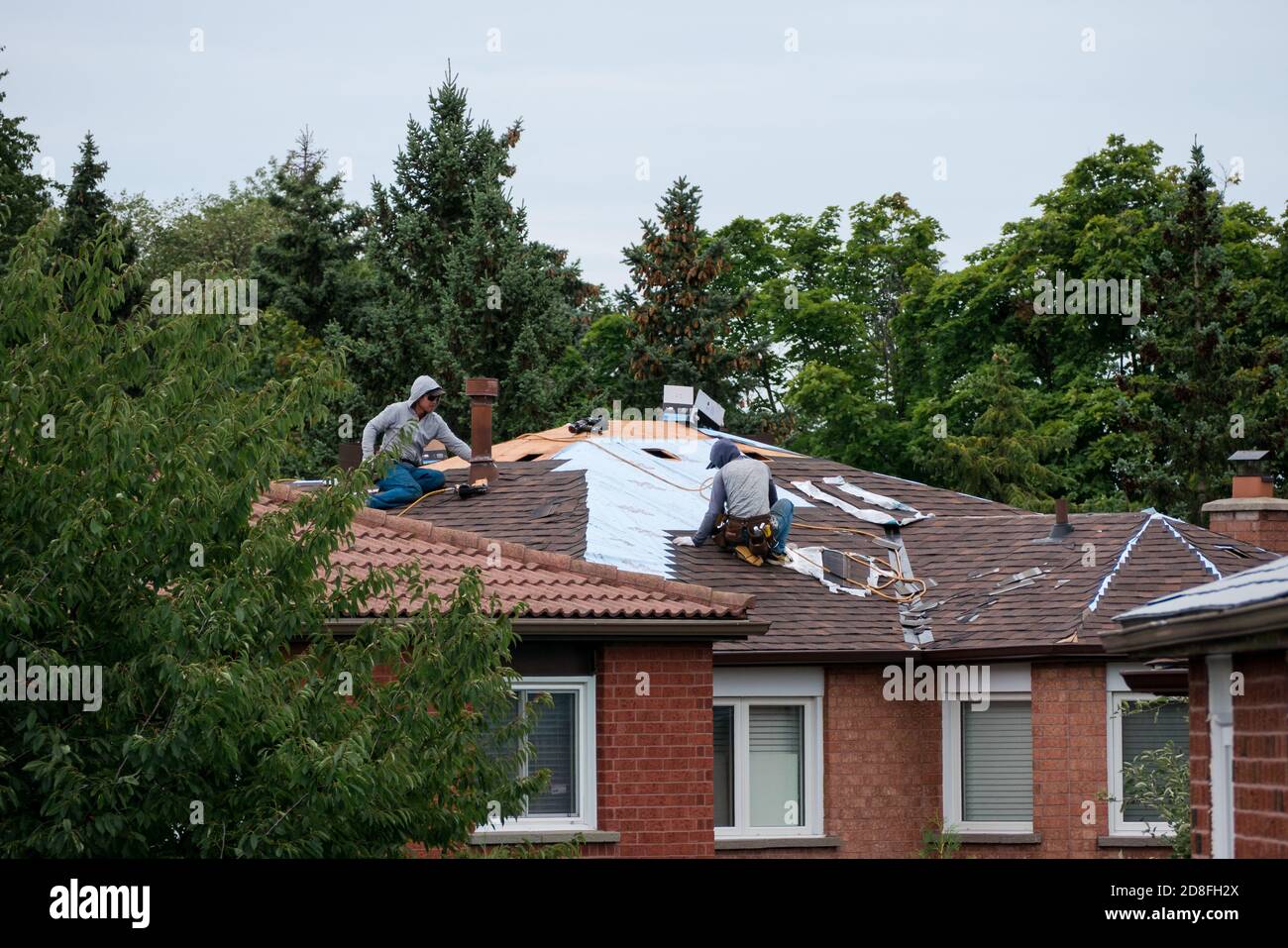 deux hommes réparent le toit d'une maison au canada Banque D'Images