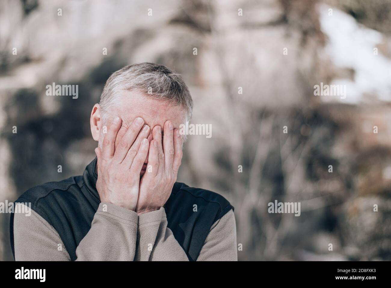 Portrait d'un homme d'âge moyen dans la rue, couvrant son visage avec ses mains. Expression de tristesse, de doute, de désespoir. Concept de crise. Copier l'espace. Banque D'Images