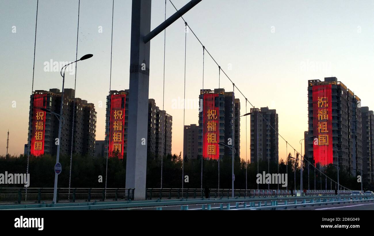 Des drapeaux chinois sont mis en place sur les bâtiments d'une rue de la ville d'Urumchi, dans la région autonome du Xinjiang au nord-ouest de la Chine, le 30 septembre 2020. Banque D'Images