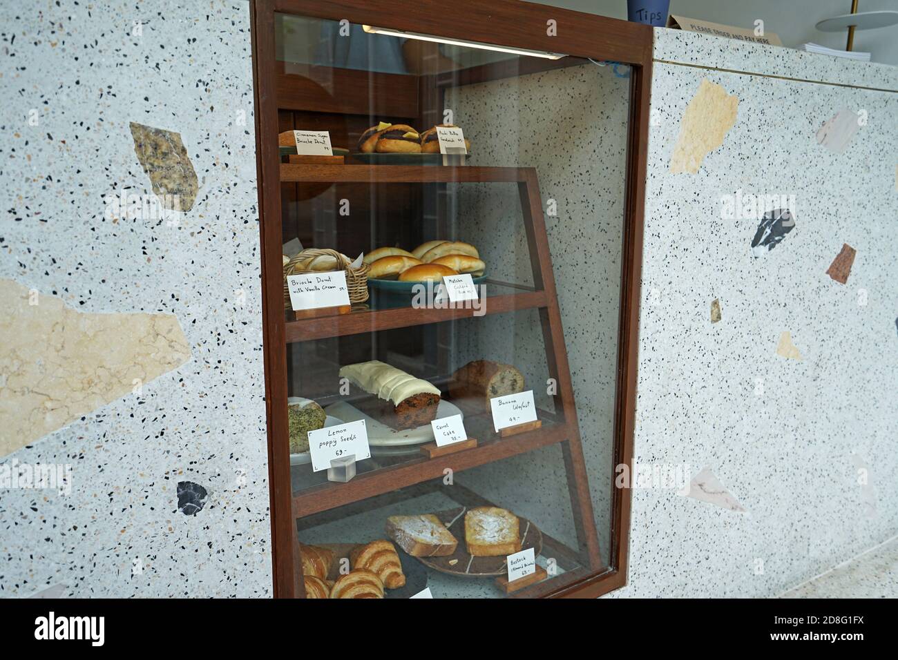 Présentoir de pâtisseries en bois et en marbre avec boîte de présentation : croissant au beurre, gâteau à la carotte, toast seedsม aux amandes et beignets au pavot au citron Banque D'Images