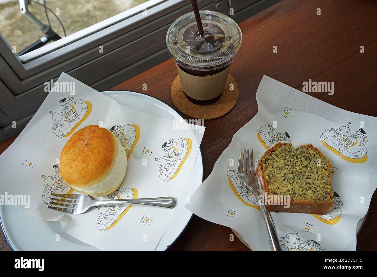 Gros plan sur le donut de brioche à la vanille française et les graines de pavot au citron Gâteau à la livre servi avec du café glacé noir sur une table en bois Banque D'Images