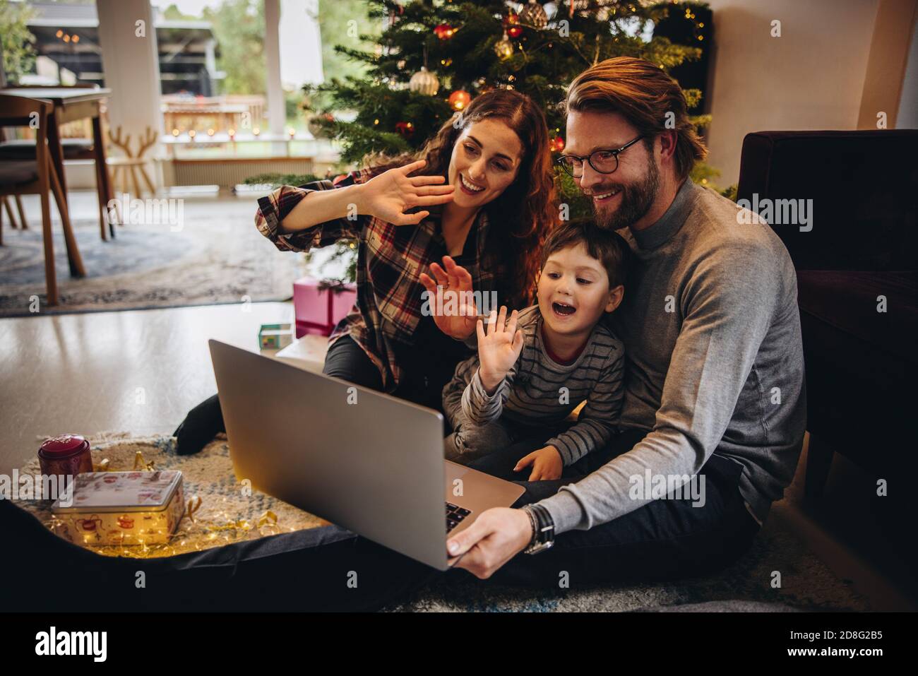 La famille se connecte en ligne avec ses proches à l'aide d'un ordinateur portable et passe un appel vidéo depuis la maison pendant Noël. Fête de Noël en famille Banque D'Images