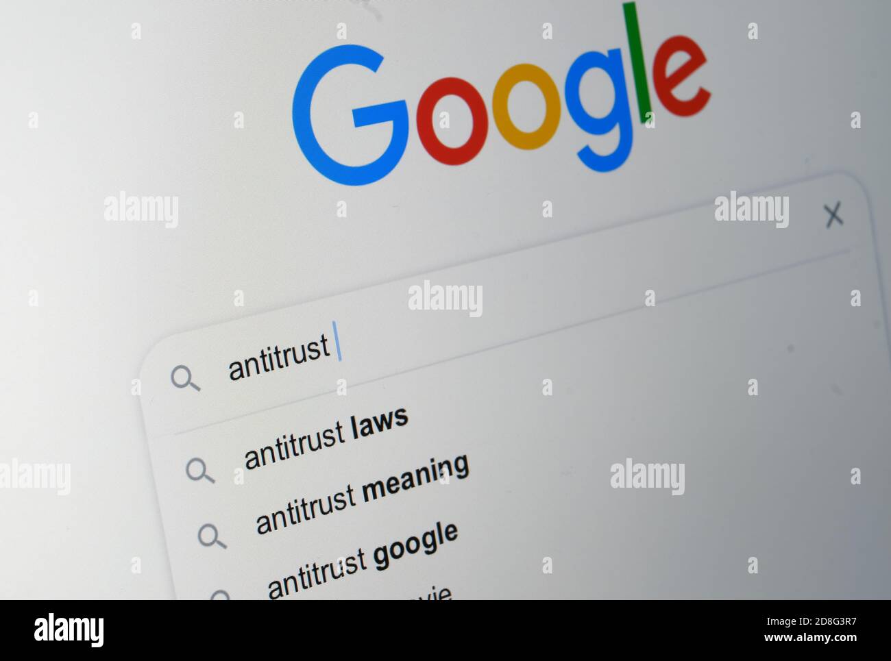 Mot antitrust tapé dans une barre de recherche avec le logo google visible sur l'arrière-plan flou. Mise au point sélective. Concept. Banque D'Images