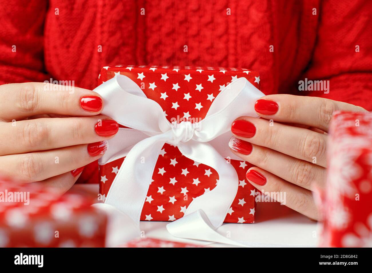 Femme noue un noeud de ruban et emballer des cadeaux gros plan Photo Stock  - Alamy