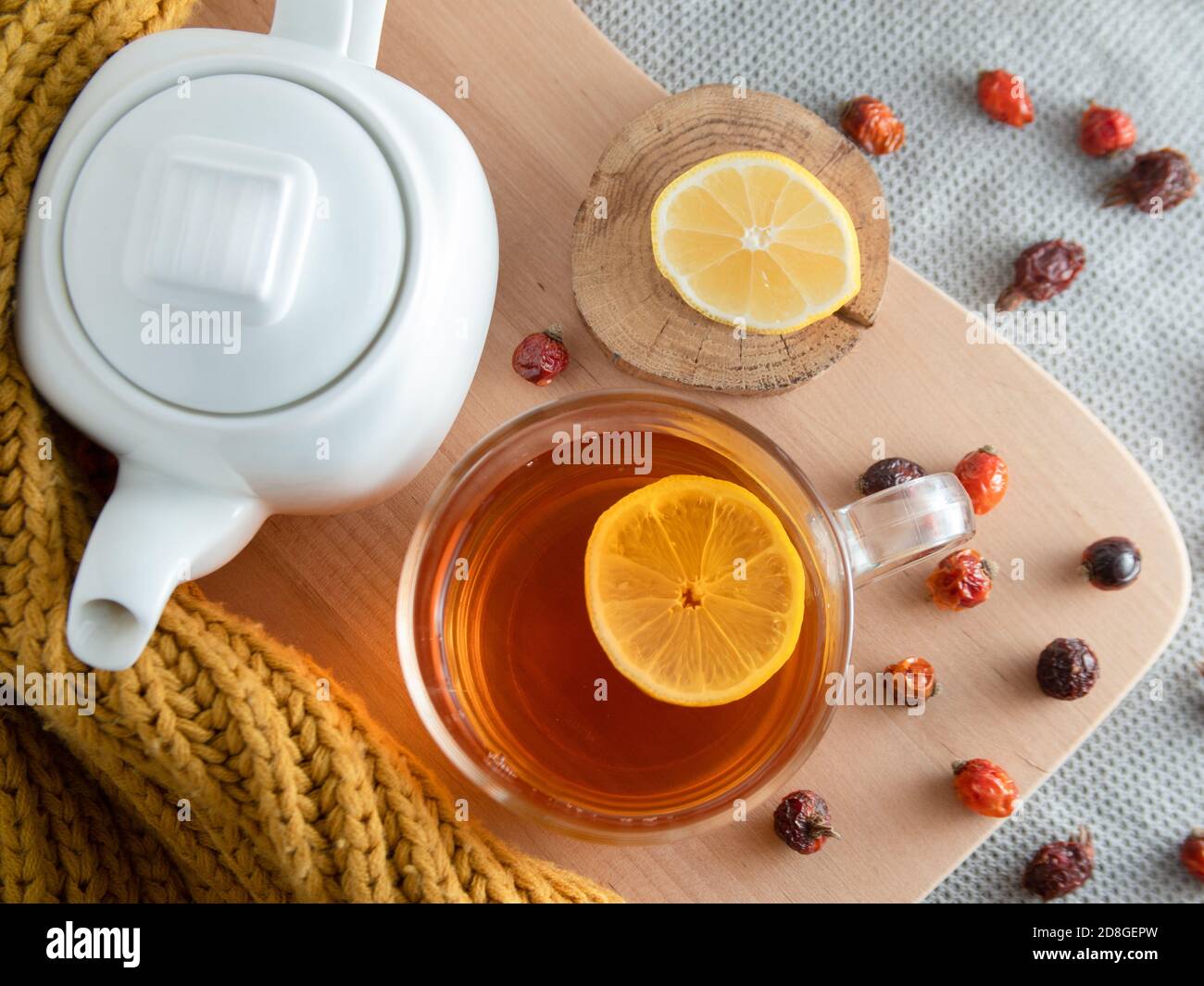la vie en automne. théière blanche, thé dans une tasse, tranches de citron et hanches de rose séchées Banque D'Images