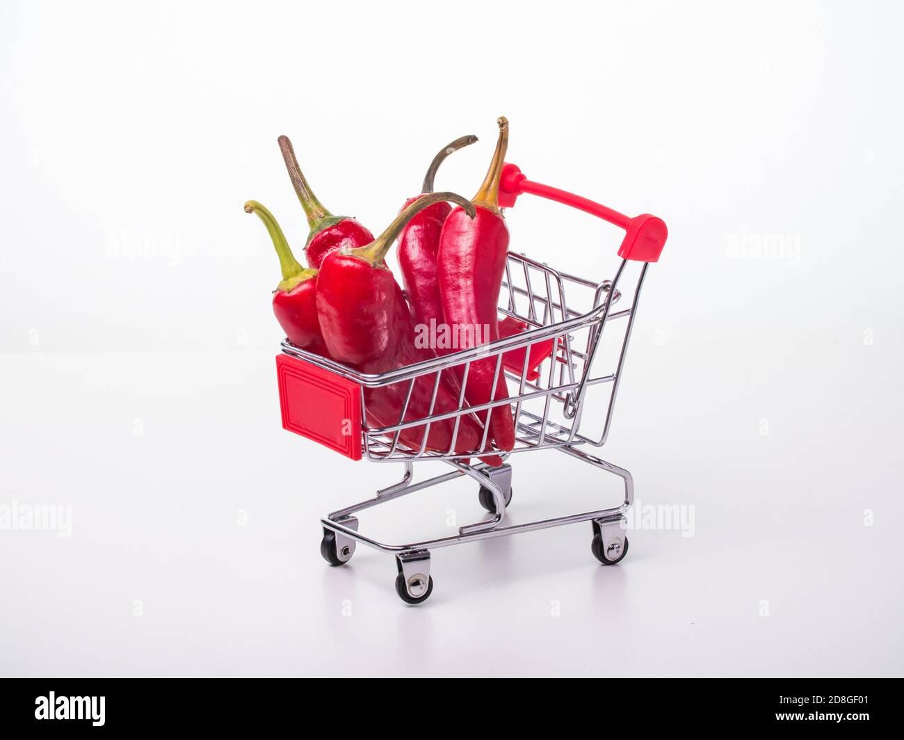 piments rouges dans un panier sur roulettes. piments rouges sur fond blanc Banque D'Images