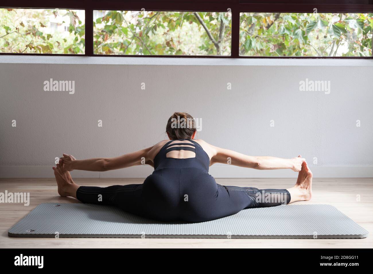Femme sportive pratiquant le yoga dans un studio de loft lumineux Banque D'Images