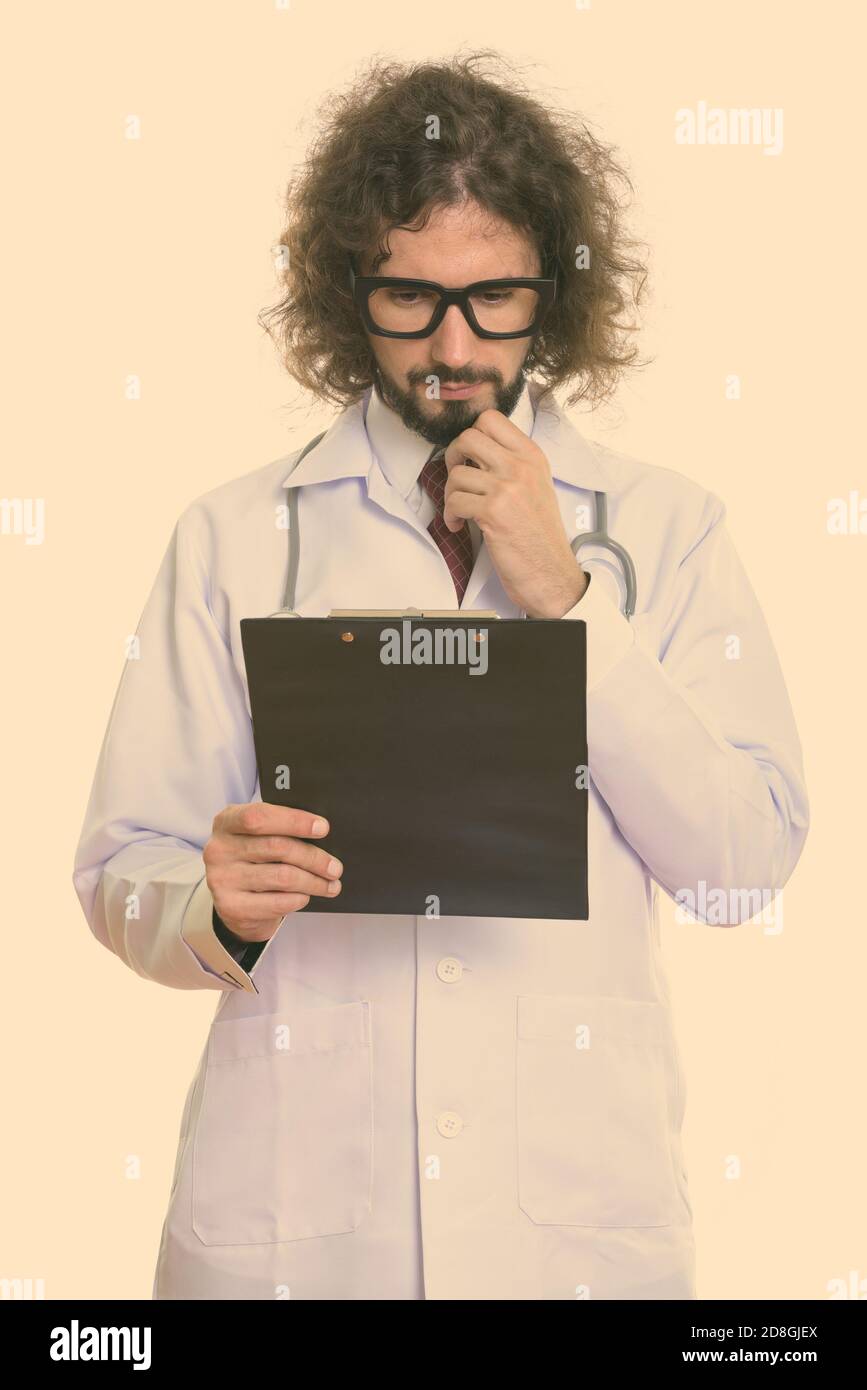 Studio shot of bel homme médecin lecture le presse-papiers en pensant Banque D'Images