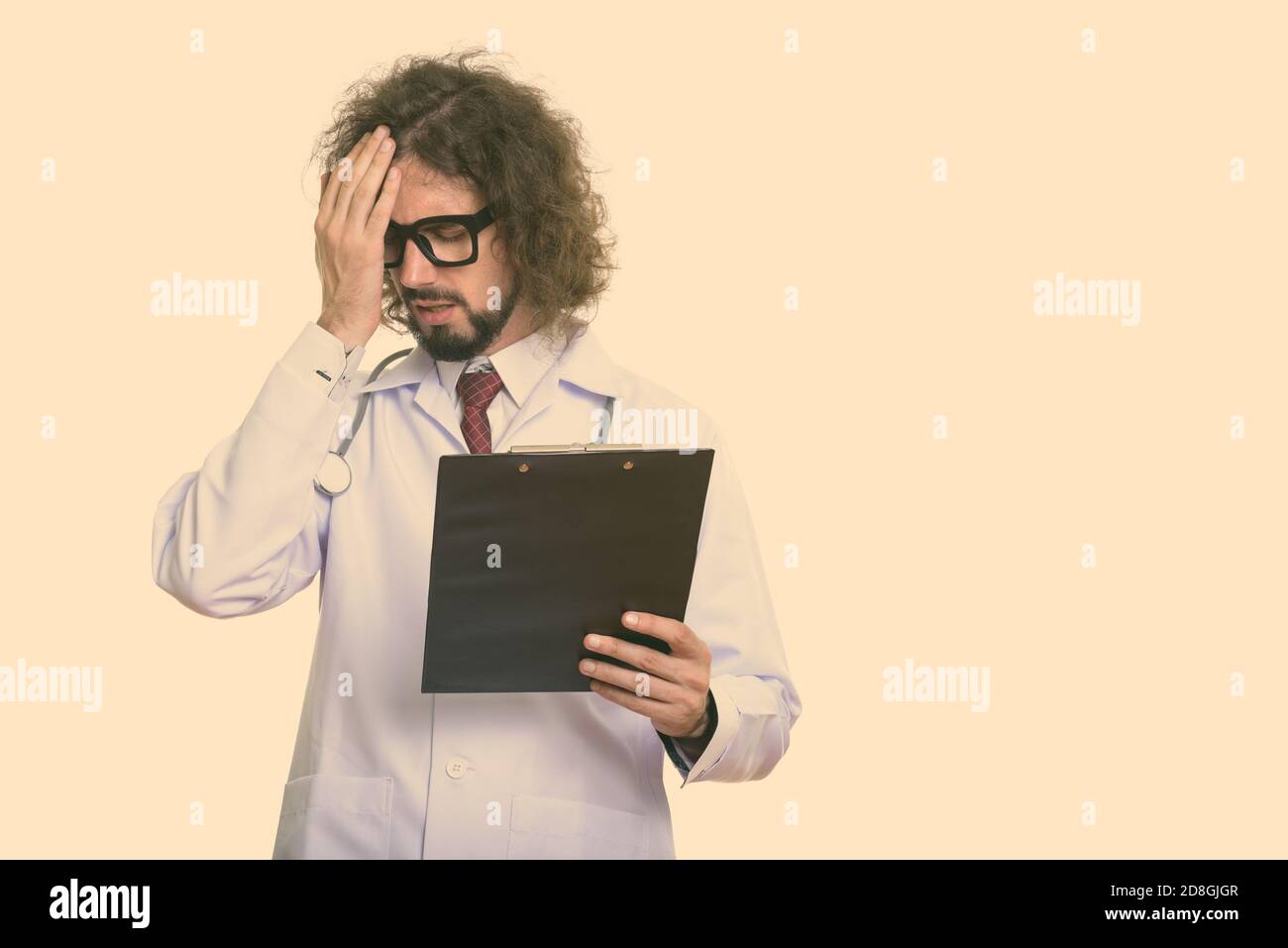 Studio shot of a souligné l'homme doctor holding clipboard Banque D'Images