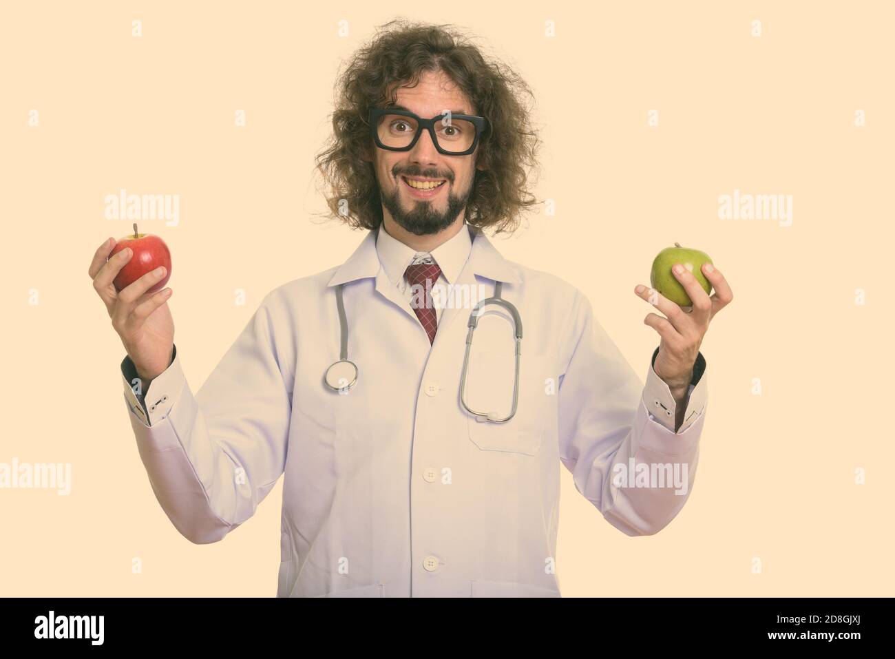 Homme heureux médecin smiling while holding Red Apple et Apple vert Banque D'Images