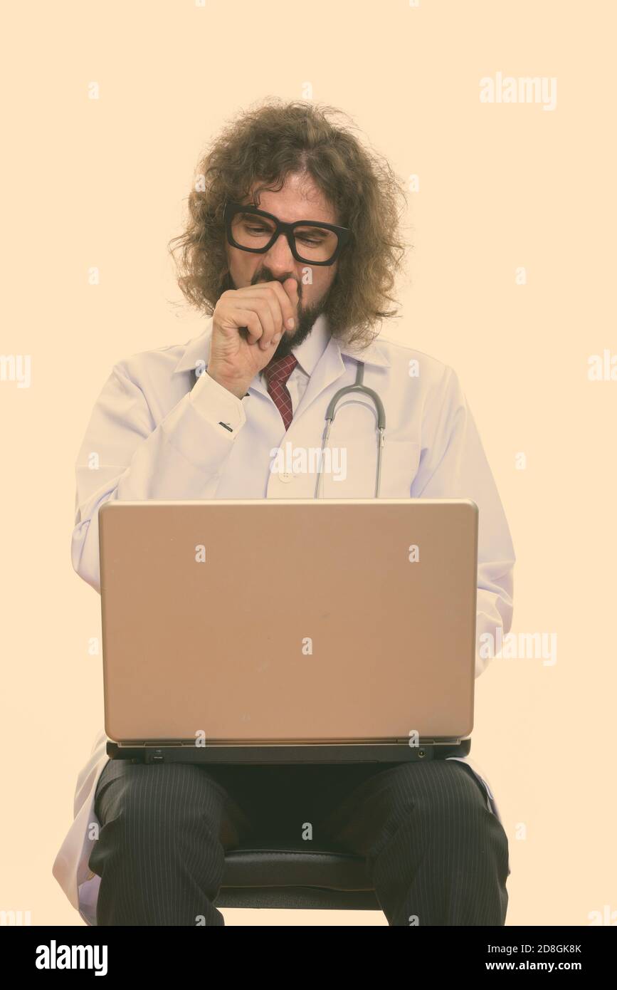 Portrait de l'homme fatigué médecin à l'aide d'ordinateur portable tout en baillant Banque D'Images