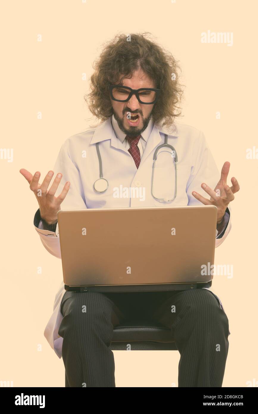 Portrait d'homme en colère (médecin) en utilisant un ordinateur portable avec les deux bras levés Banque D'Images