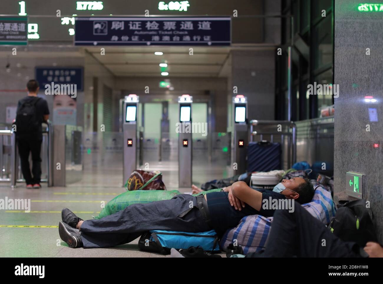 Vue des travailleurs migrants dormant sur le sol et des chaises aux alentours de 3a.M. à la gare de Beijing, Chine, 12 septembre 2020. Banque D'Images