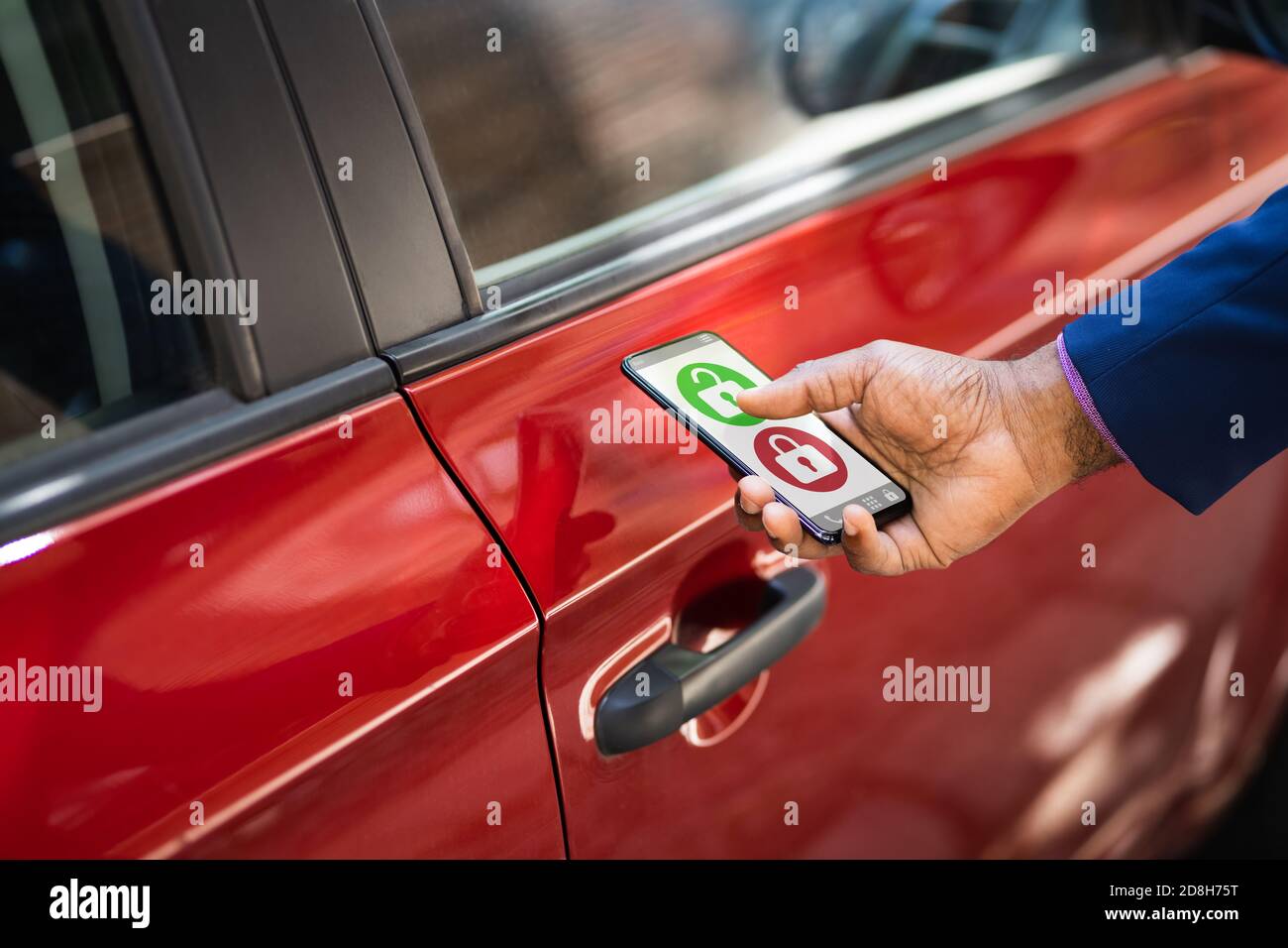 African Man Unlocking car à l'aide de l'application pour smartphone Banque D'Images
