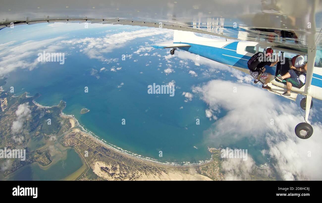 Parachutistes accrochés à l'avion, dans un endroit paradisiaque. Banque D'Images