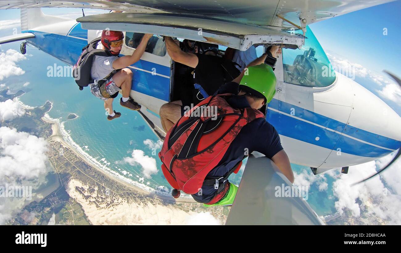 Parachutistes accrochés à l'avion, dans un endroit paradisiaque. Banque D'Images