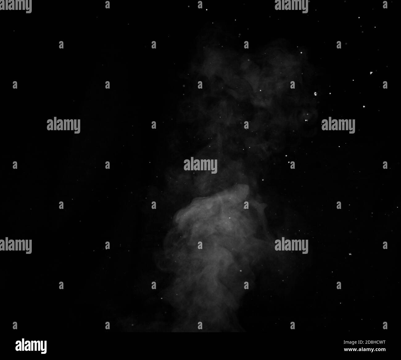Vapeur blanche pulvérisée du saturateur d'air. Fragments de fumée sur fond noir. Arrière-plan abstrait Banque D'Images