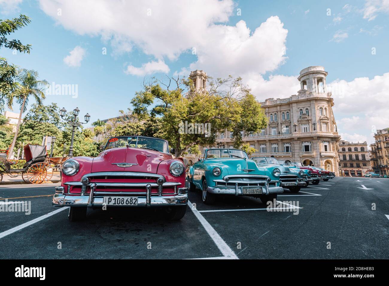Des voitures rétro classiques aux couleurs vives différentes sont garées devant le Musée national des beaux-arts sur la place, près du monument de José Marti Banque D'Images