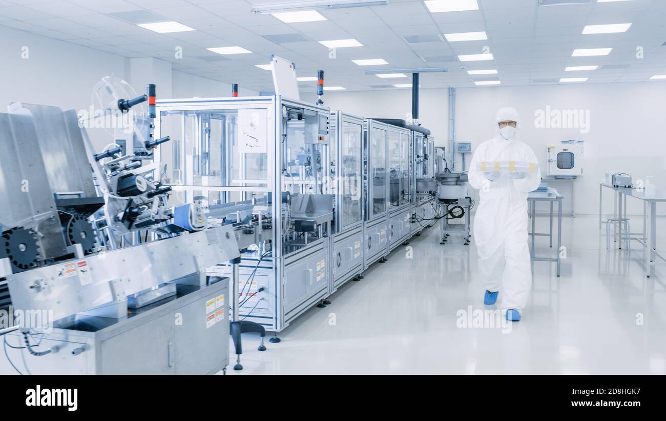 Photo du laboratoire de fabrication de produits pharmaceutiques stériles où des scientifiques de la combinaison de protection font de la recherche, du contrôle de la qualité et travaillent sur le Banque D'Images