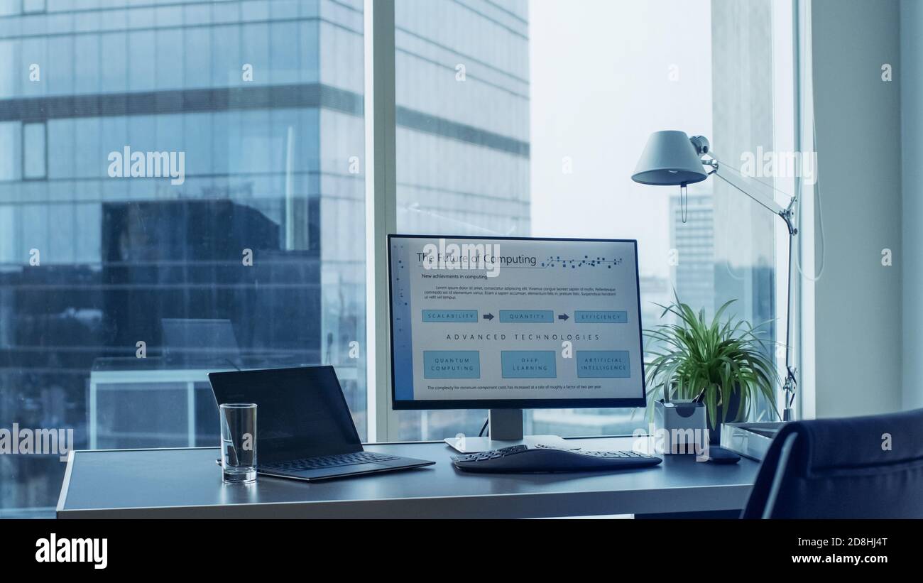 Photo du bureau avec un ordinateur personnel debout. Plans de calcul futurs affichés sur le moniteur. Chambre moderne et élégante avec une grande ville d'affaires Banque D'Images
