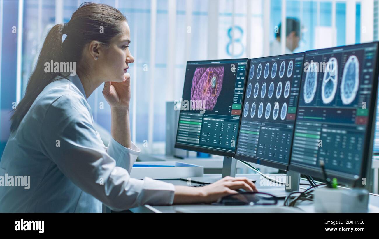 Scientifique de recherche médicale féminine travaillant avec des images du cerveau sur son ordinateur personnel. Laboratoire moderne travaillant sur la neurophysiologie, Science Banque D'Images