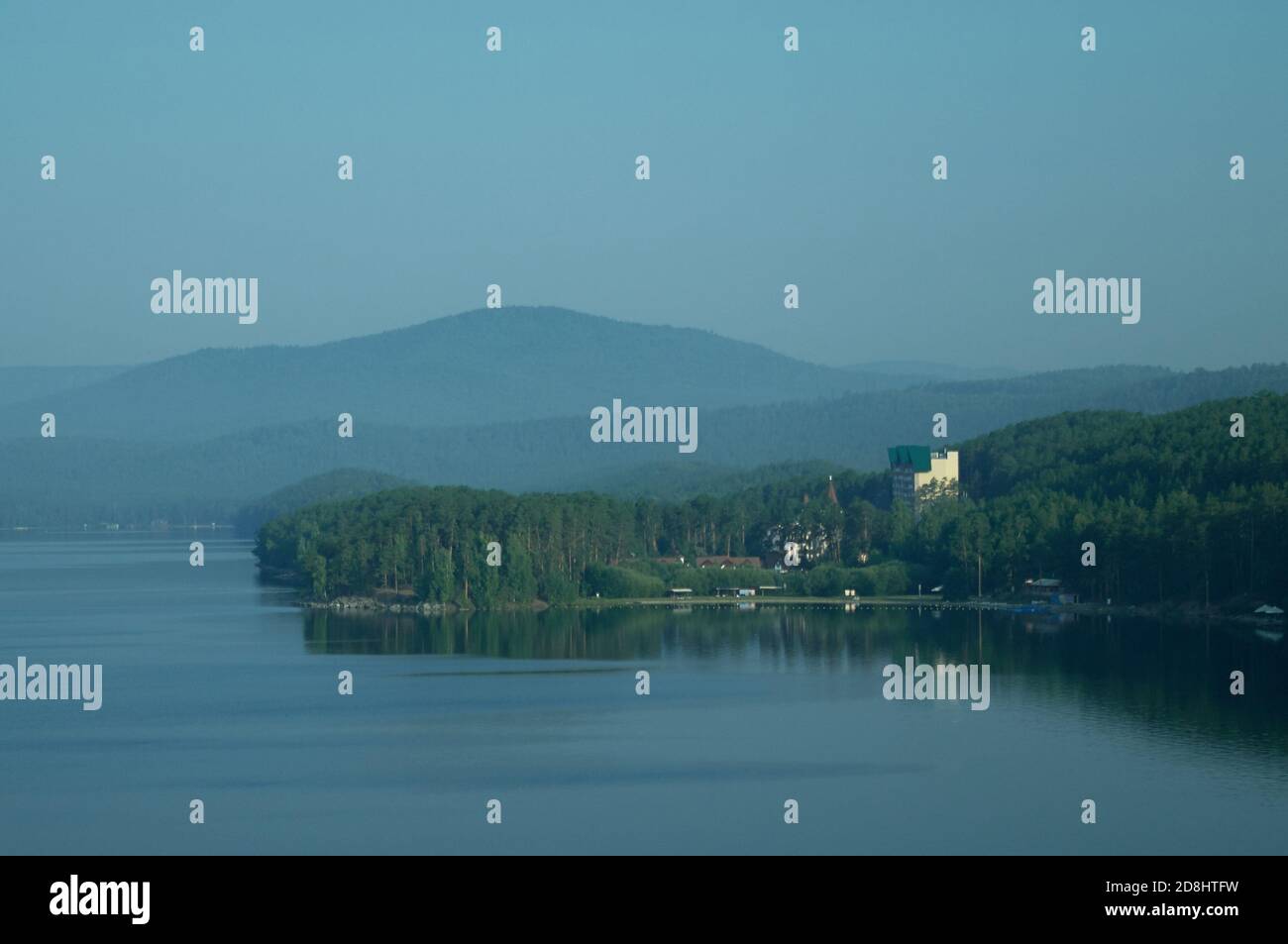 Lac, hôtels, parcs et plages situés sur la rive du lac, entouré de forêts et de montagnes. Banque D'Images